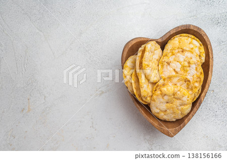 Crispy rice crackers served in rustic wooden bowl. Minimal food composition with clean background. 138156166
