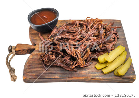 Smoked pulled beef brisket served on wooden board with pickles and sauce, rustic barbecue food, Texas style comfort meat dish. Smoked pulled beef brisket served on wooden board with pickles and sauce, rustic barbecue food, Texas style comfort meat dish. 138156173