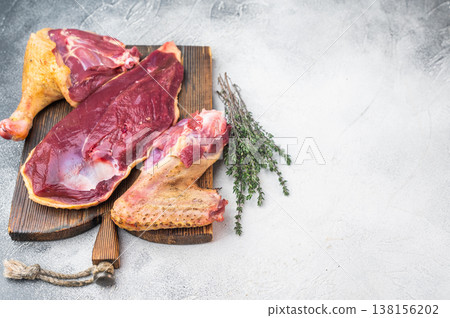 Raw duck meat assortment with breast leg and trimmings on rustic board. Gamebird poultry game meat food still life. Raw duck meat assortment with breast leg and trimmings on rustic board. Gamebird poultry game meat food still life. 138156202