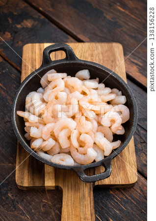 Cooked mini prawns in rustic skillet, salad shrimp portion on wooden surface, healthy protein seafood for catering and restaurant concept.. Cooked mini prawns in rustic skillet, salad shrimp portion on wooden surface, healthy protein seafood for catering and restaurant concept.. 138156228