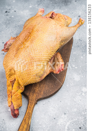 Uncooked whole duck poultry with seasoning and thyme ready for roasting, Gamebird shown on bright stone surface top view with copy space. Uncooked whole duck poultry with seasoning and thyme ready for roasting, Gamebird shown on bright stone surface top view with copy space. 138156233