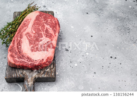 Premium raw beef ribeye entrecote steak with visible fat marbling. Natural fresh meat cut on rustic background with copy space. Premium raw beef ribeye entrecote steak with visible fat marbling. Natural fresh meat cut on rustic background with copy space. 138156244