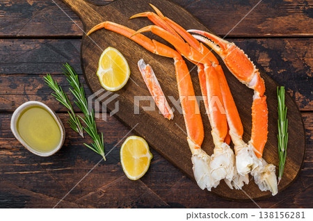 Gourmet boiled king red crab legs with lemon rosemary and butter on rustic board dark background high quality seafood Gourmet boiled king red crab legs with lemon rosemary and butter on rustic board dark background high quality seafood 138156281