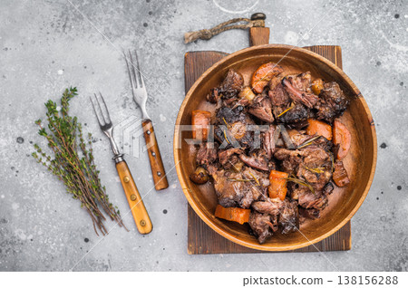 Slow cooked oxtails with vegetables, thyme and rosemary, hearty comfort food in rustic wooden bowl, top view Slow cooked oxtails with vegetables, thyme and rosemary, hearty comfort food in rustic wooden bowl, top view 138156288