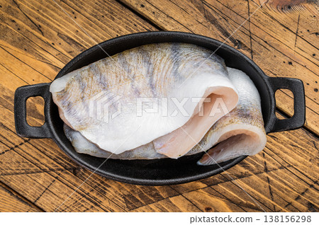 Fresh zander fillet, also known as walleye or pike perch, raw white freshwater fish prepared for cooking in rustic kitchen setting. 138156298