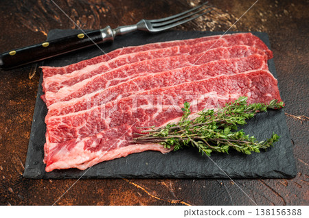 Raw marbled beef short plate slices on slate board with thyme, premium angus meat with rich fat texture on dark background 138156388
