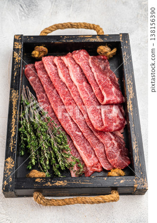 Thin sliced marbled beef for hot pot or shabu shabu, fresh premium meat on serving tray with chopsticks, Asian cuisine concept Thin sliced marbled beef for hot pot or shabu shabu, fresh premium meat on serving tray with chopsticks, Asian cuisine concept 138156390