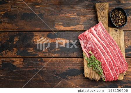 Raw marbled beef bacon slices on rustic wooden board with herbs and pepper, premium angus meat, gourmet cooking ingredient with copy space 138156406