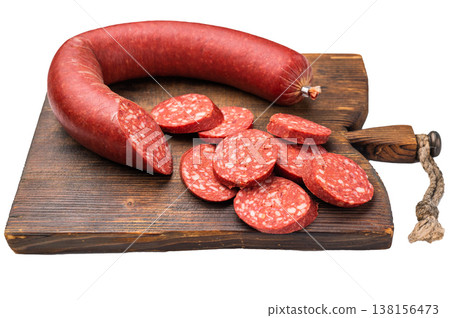 Whole and sliced Turkish sucuk (sujuk) on a rustic cutting board. Traditional spicy dry-cured sausage. Whole and sliced Turkish sucuk (sujuk) on a rustic cutting board. Traditional spicy dry-cured sausage. 138156473
