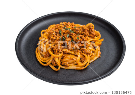 Hearty Italian bolognese pasta topped with savory meat sauce on dark plate against bright neutral backdrop, top view food shot. Hearty Italian bolognese pasta topped with savory meat sauce on dark plate against bright neutral backdrop, top view food shot. 138156475