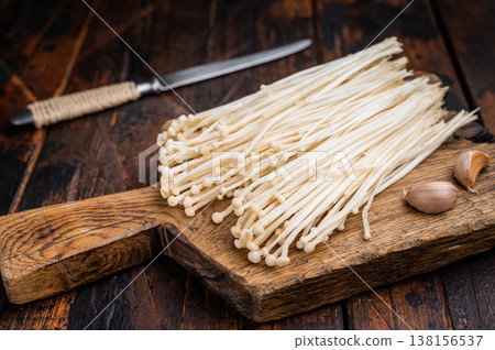Fresh raw Enoki mushrooms (Flammulina filiformis) in a black plastic retail container on a clean white background. Ready for sale. Fresh raw Enoki mushrooms (Flammulina filiformis) in a black plastic retail container on a clean white background. Ready for sale. 138156537