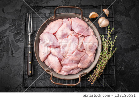 Top view of uncooked quail meat in a rustic skillet with fresh thyme. Premium ingredients for a gourmet recipe. Top view of uncooked quail meat in a rustic skillet with fresh thyme. Premium ingredients for a gourmet recipe. 138156551
