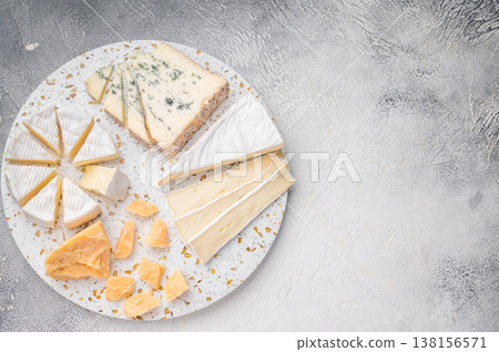Brie Camembert Parmesan and Roquefort arranged on a terrazzo board against a textured light gray background for a bright gourmet look. Brie Camembert Parmesan and Roquefort arranged on a terrazzo board against a textured light gray background for a bright gourmet look. 138156571