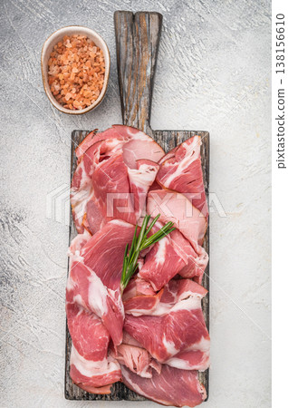 Italian coppa capocollo slices arranged on rustic wood with rosemary similar to Spanish lomo embuchado on a bright clean background for stock use. Italian coppa capocollo slices arranged on rustic wood with rosemary similar to Spanish lomo embuchado on a bright clean background for stock use. 138156610