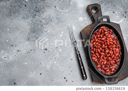 Kidney beans in a cast iron skillet on a rustic wooden board. Large gray copy space for text. Overhead, minimal style. 138156619