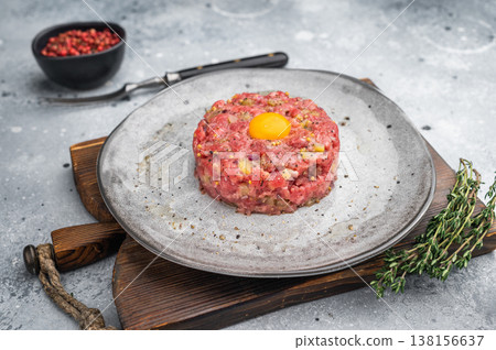 Fresh beef tartare with yolk on stone dish and wooden board great for gourmet cooking protein rich meals and high quality food photography. Fresh beef tartare with yolk on stone dish and wooden board great for gourmet cooking protein rich meals and high quality food photography. 138156637