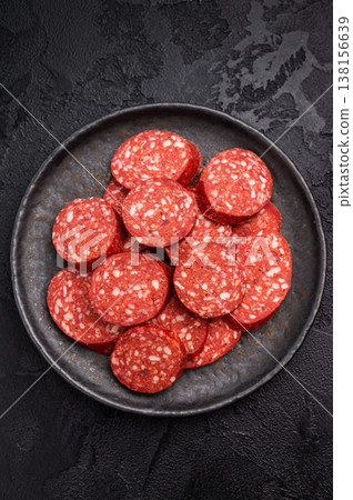 Pile of sliced Turkish sucuk (sujuk) on a dark plate. Traditional spicy dry-cured sausage, ready to eat. Pile of sliced Turkish sucuk (sujuk) on a dark plate. Traditional spicy dry-cured sausage, ready to eat. 138156639
