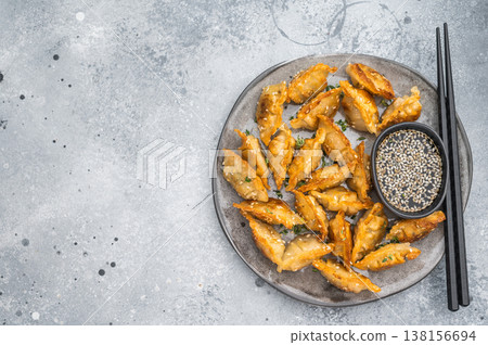 Crispy pan fried jiaozi dumplings with sesame served on dark plate. Asian mandu potstickers 138156694