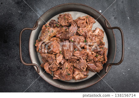 Slowcooked wild venison moose meat, tender and juicy, served with rosemary on rustic metal plate against dark textured stone surface Slowcooked wild venison moose meat, tender and juicy, served with rosemary on rustic metal plate against dark textured stone surface 138156714