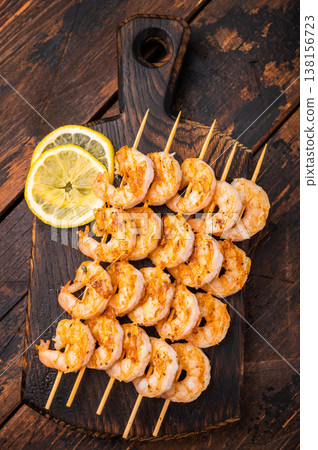 Gourmet seafood appetizer: spiced prawn shrimp kebabs served on a weathered dark wood table. Perfect for menus and recipe books. Gourmet seafood appetizer: spiced prawn shrimp kebabs served on a weathered dark wood table. Perfect for menus and recipe books. 138156723