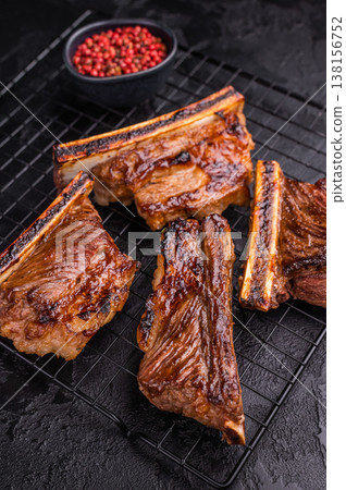 High contrast BBQ ribs shot with pink peppercorns. Dark and moody food photography for web banners. 138156752
