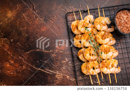 Grilled shrimp prawn skewers on a dark rustic background. Delicious seafood kebab, perfect for a gourmet appetizer or dinner menu. Grilled shrimp prawn skewers on a dark rustic background. Delicious seafood kebab, perfect for a gourmet appetizer or dinner menu. 138156758
