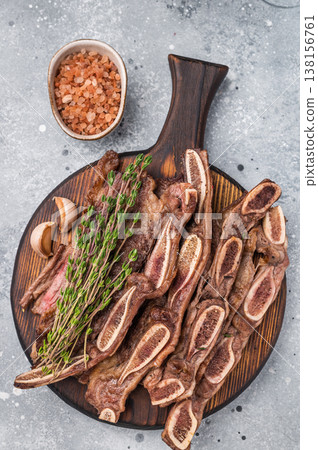 Top view of premium Korean BBQ Kalbi on a rustic wooden platter. Light textured background for advertising or menu design. Top view of premium Korean BBQ Kalbi on a rustic wooden platter. Light textured background for advertising or menu design. 138156761