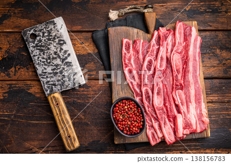 Premium quality raw cross-cut short ribs ready for preparation, set against a dark, rustic wood backdrop. Premium quality raw cross-cut short ribs ready for preparation, set against a dark, rustic wood backdrop. 138156783