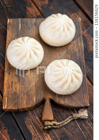Nikuman steamed buns with dipping sauce and sesame seeds on rustic wooden background, Asian street food with copy space 138156829