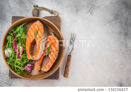 Grilled salmon steaks also known as red fish served in wooden bowl with fresh salad, light background with copy space Grilled salmon steaks also known as red fish served in wooden bowl with fresh salad, light background with copy space 138156837
