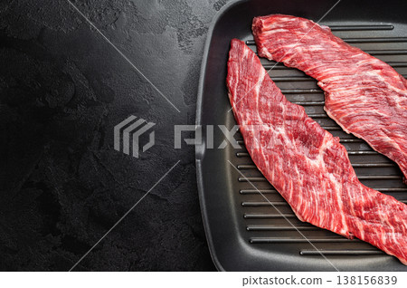 Closeup raw beef premium steak on grill pan showing texture and grain, uncooked meat ready for searing grilling or barbecue cooking 138156839