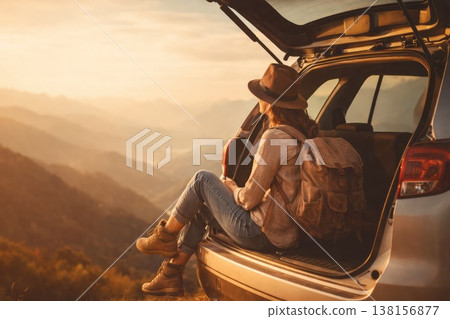Female Traveler Sitting in Car Trunk Enjoying Mountain Sunset View 138156877