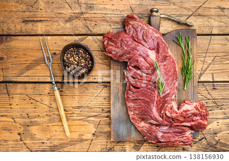 Butcher style raw beef diaphragm hanger steak on cutting board, natural wood table background with copy space, perfect for cooking and bbq themes 138156930