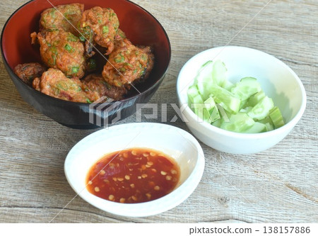 fried grouper fish patty with slice cucumber on bowl dipping sweet chili sauce fried grouper fish patty with slice cucumber on bowl dipping sweet chili sauce 138157886
