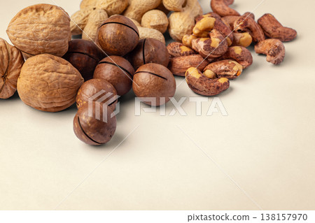 Mixed nuts with nutshell, walnut, macadamia, cashew, peanuts on brown background Mixed nuts with nutshell, walnut, macadamia, cashew, peanuts on brown background 138157970