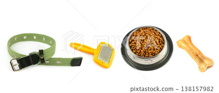 Comprehensive set of essential pet care accessories including a green textile collar, yellow grooming slicker brush, stainless steel bowl filled with dry food, and a rawhide bone isolated on white. Comprehensive set of essential pet care accessories including a green textile collar, yellow grooming slicker brush, stainless steel bowl filled with dry food, and a rawhide bone isolated on white. 138157982