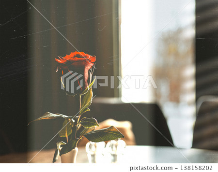 A beautiful red rose in a vase on a table with a moody vintage film effect. Romantic still life with a nostalgic dust textures. Valentine's Day, love. A beautiful red rose in a vase on a table with a moody vintage film effect. Romantic still life with a nostalgic dust textures. Valentine's Day, love. 138158202