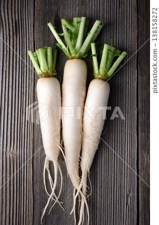 Fresh daikon radish with greens on rustic wooden surface 138158272