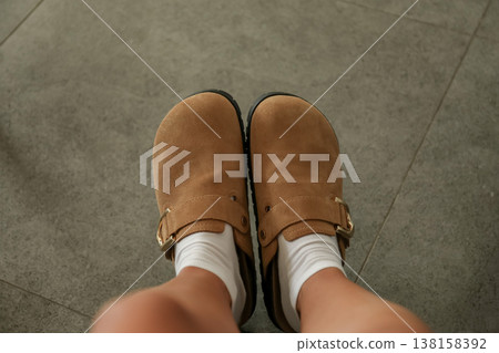 Person is wearing brown shoes with white socks indoors Person is wearing brown shoes with white socks indoors 138158392