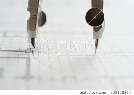Close-up of an architect's hands working on a draft: creating architectural drawings using a compass. Close-up of an architect's hands working on a draft: creating architectural drawings using a compass. 138158853