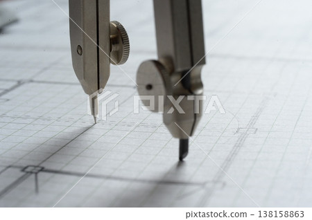 Close-up of an architect's hands working on a draft: creating architectural drawings using a compass. Close-up of an architect's hands working on a draft: creating architectural drawings using a compass. 138158863