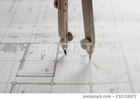 Close-up of an architect's hands working on a draft: creating architectural drawings using a compass. Close-up of an architect's hands working on a draft: creating architectural drawings using a compass. 138158872
