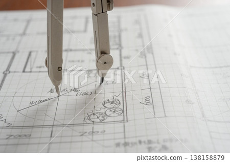 Close-up of an architect's hands working on a draft: creating architectural drawings using a compass. 138158879