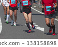The dynamic movement of the feet and running shoes of amateur runners running smoothly in a marathon 138158898