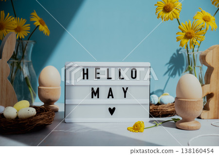Phrase HELLO MAY traditional greeting to christian holiday. Festive mood composition with bunnies and yellow flowers on pastel blue background. Sustainable natural materials Phrase HELLO MAY traditional greeting to christian holiday. Festive mood composition with bunnies and yellow flowers on pastel blue background. Sustainable natural materials 138160454