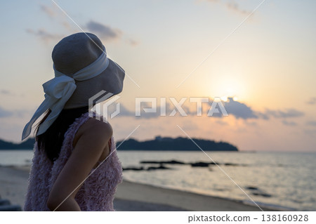 一位日本女子在沖繩海灘欣賞日落。 一位日本女子在沖繩海灘欣賞日落。 138160928