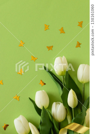 White Tulips and Butterflies Confetti with Ribbon on Green Spring Background White Tulips and Butterflies Confetti with Ribbon on Green Spring Background 138161060