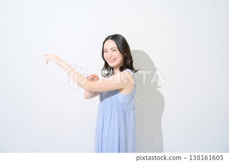 Japanese woman touching her arm against a white background Japanese woman touching her arm against a white background 138161605