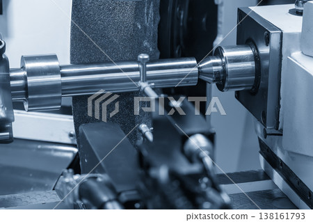 High-precision surface finishing on a metal shaft using a cylindrical grinding machine for micron-level accuracy. 138161793