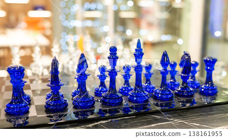Exquisite blue glass chess set on marble surface in luxury interior Exquisite blue glass chess set on marble surface in luxury interior 138161955
